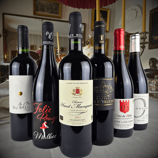 Collection of French organic red wines from Bordeaux and Rhône in elegant setting, showcasing premium vegan labels.